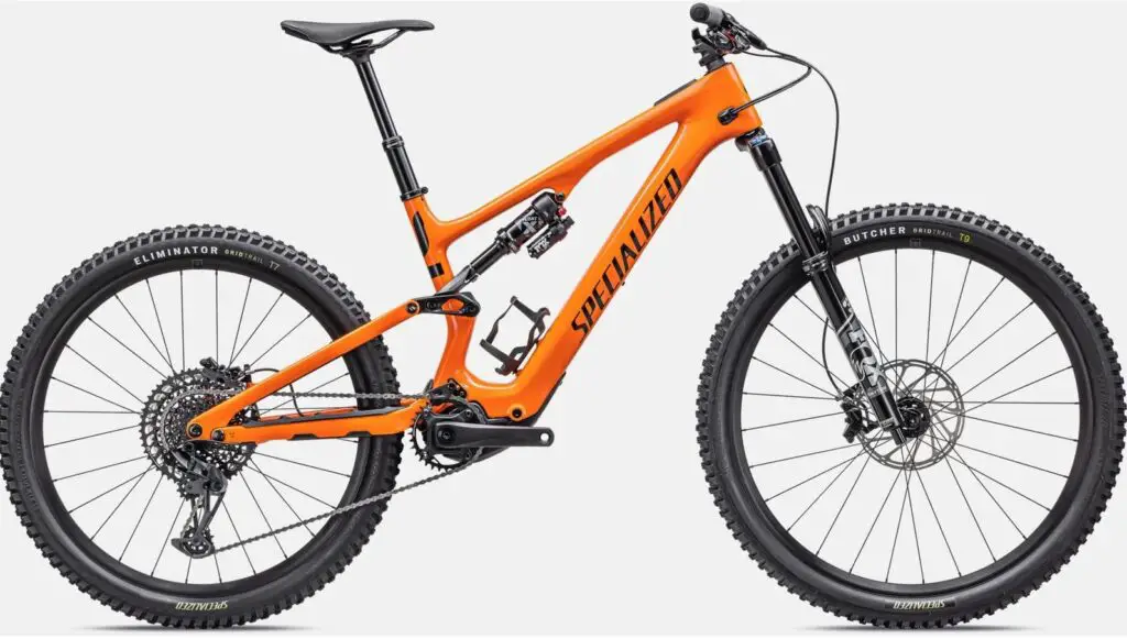 Specialized mountain bike in bright orange color with full suspension and rugged tires.