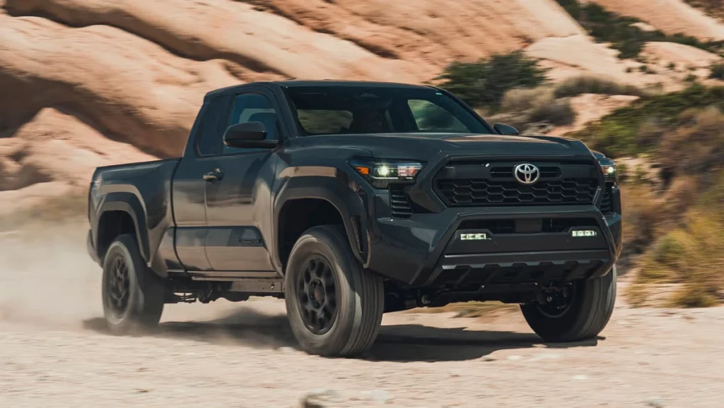 Dark colored 2026 Toyota Tacoma driving through rocky canyon