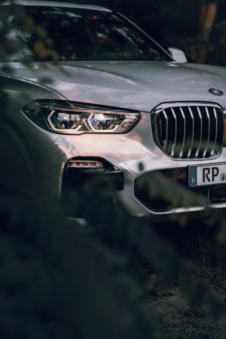 Front grille and headlights of white BMW hybrid SUV parked outdoors