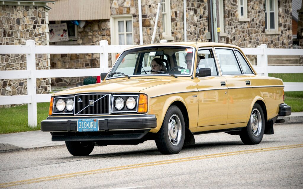 Golden Volvo 240 station wagon on a scenic road