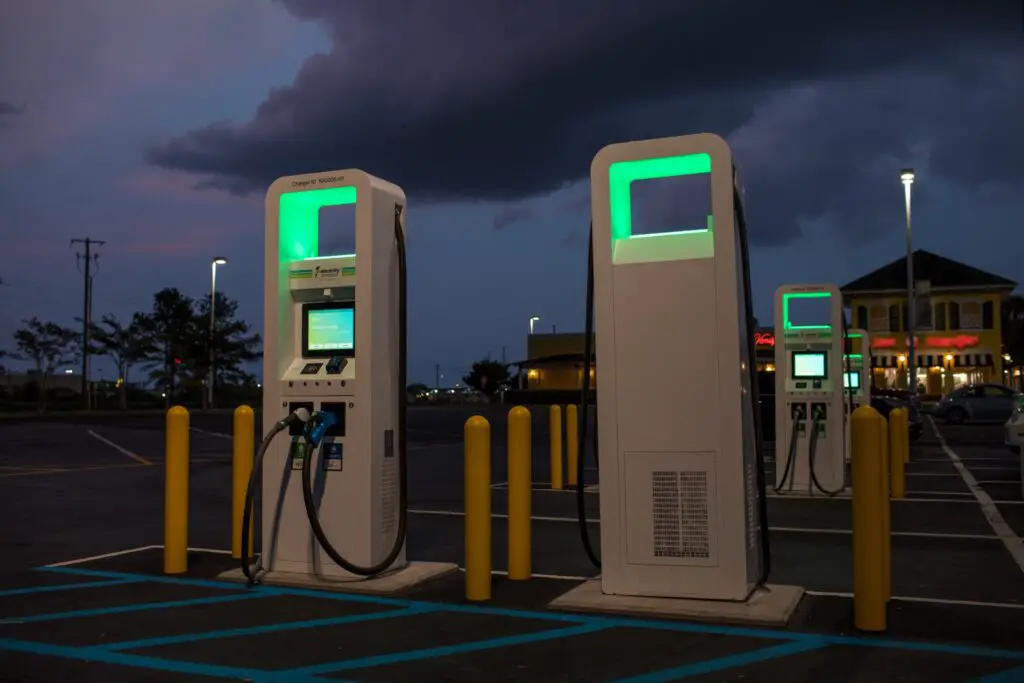 An electric vehicle charging station illuminated at night in an urban environment, illustrating the reliability of the Best EV Charging Networks in USA.