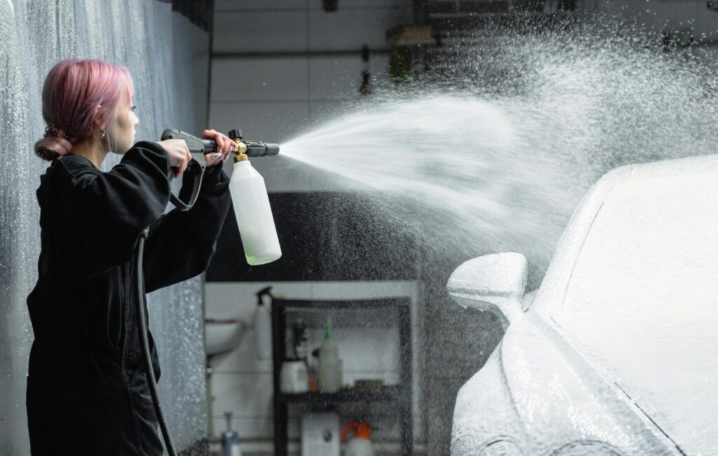Person using foam spray on a luxury car during detailing – best car wash near me in California