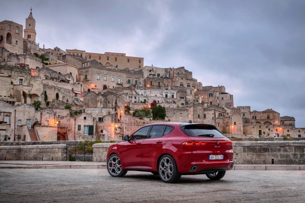 2026 Alfa Romeo Tonale rear view in red parked in historic European city street at sunset