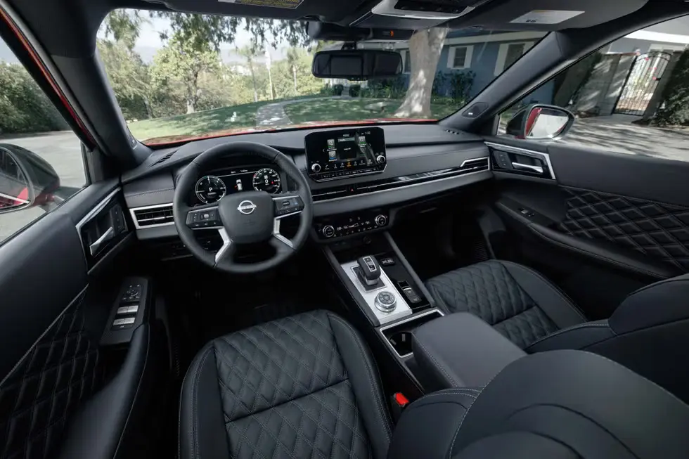 Interior front cabin view of the 2026 Nissan Rogue Plug-In Hybrid with digital dashboard and quilted seats.