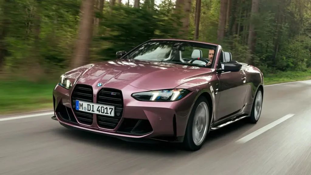 2026 BMW M4 convertible driving on road with aggressive front design and sporty stance