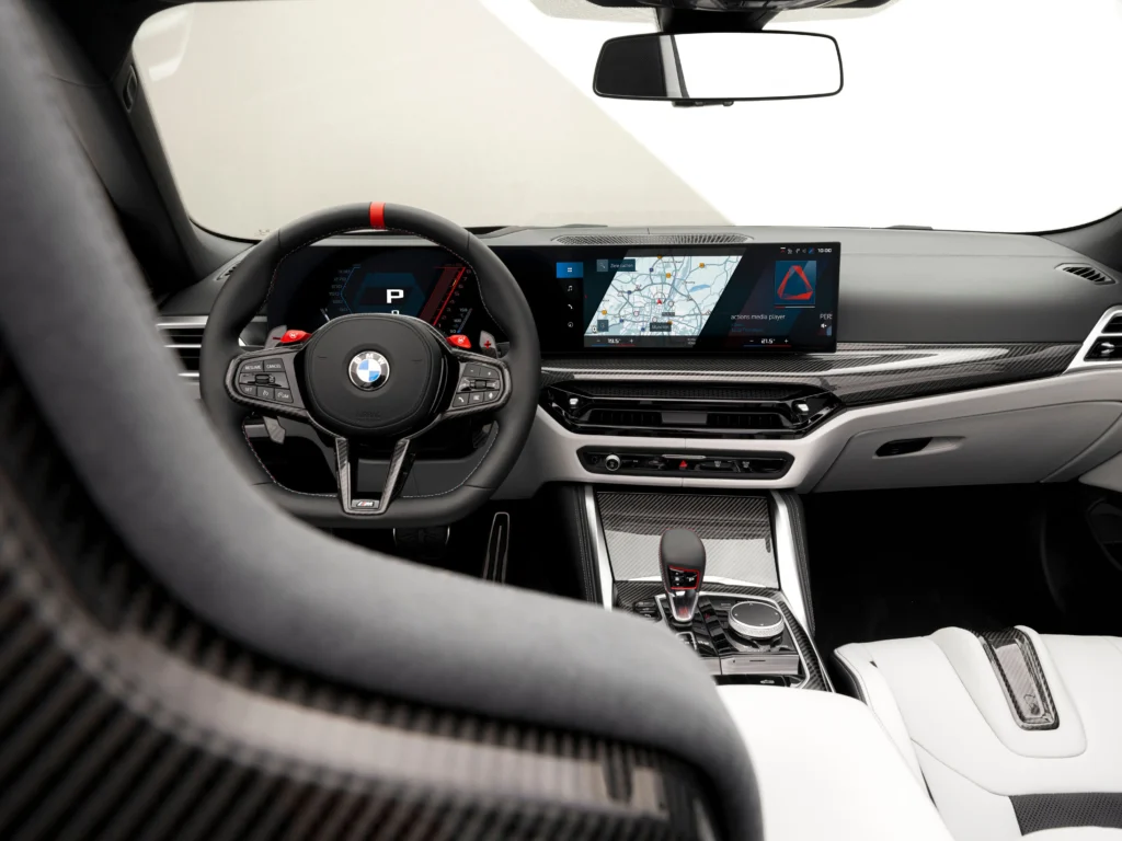 2026 BMW M4 interior with sporty steering wheel, digital display and luxury carbon fiber trim